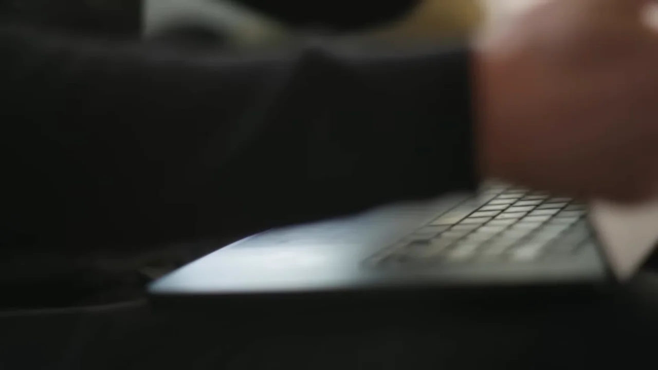 Hands open and operate a laptop.