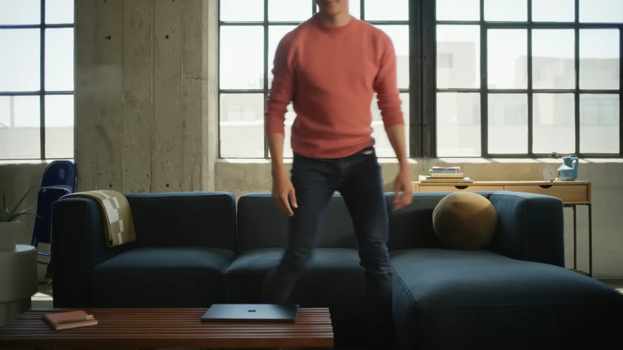 A laptop closes and a person stands.