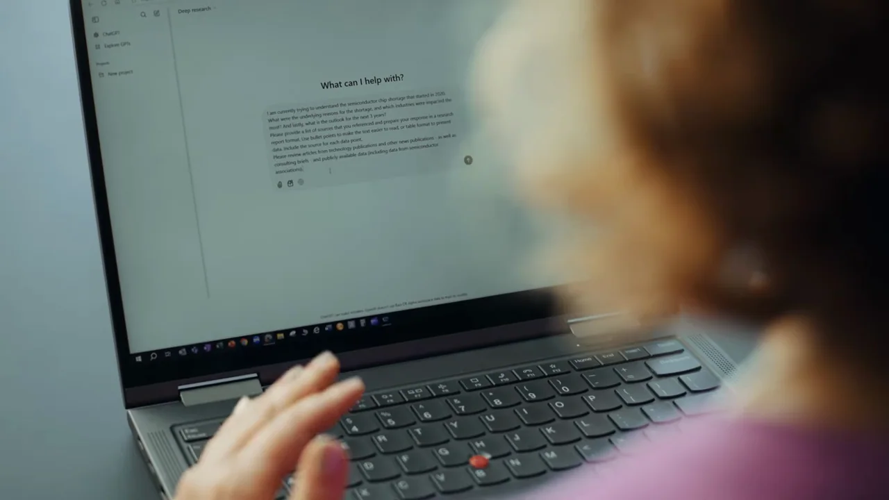 An over-the-shoulder laptop shows a research request.