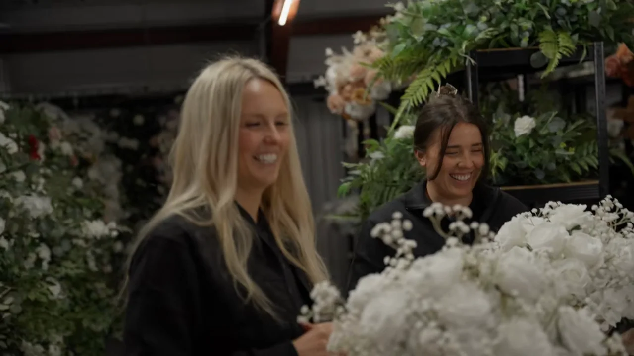Wide and close interview views lead to both people among the flowers.