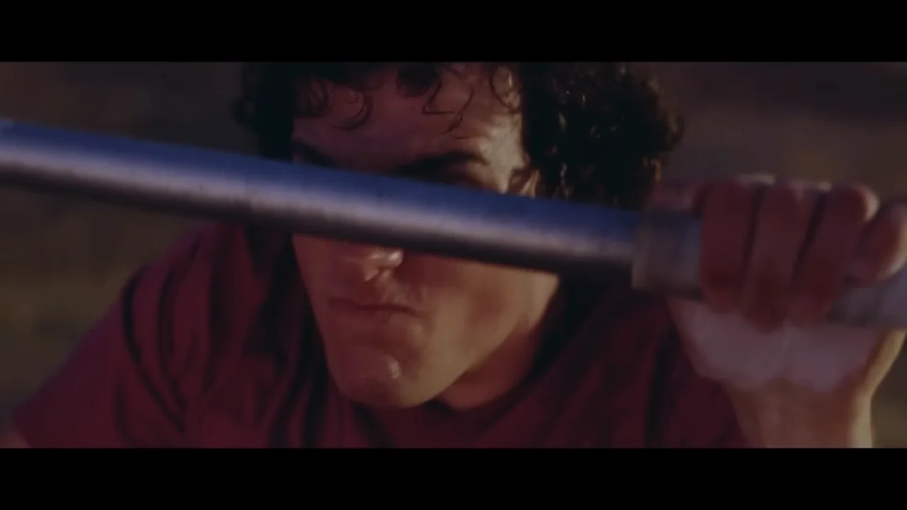 Dark close framing gives way to hands and a face at the bar.