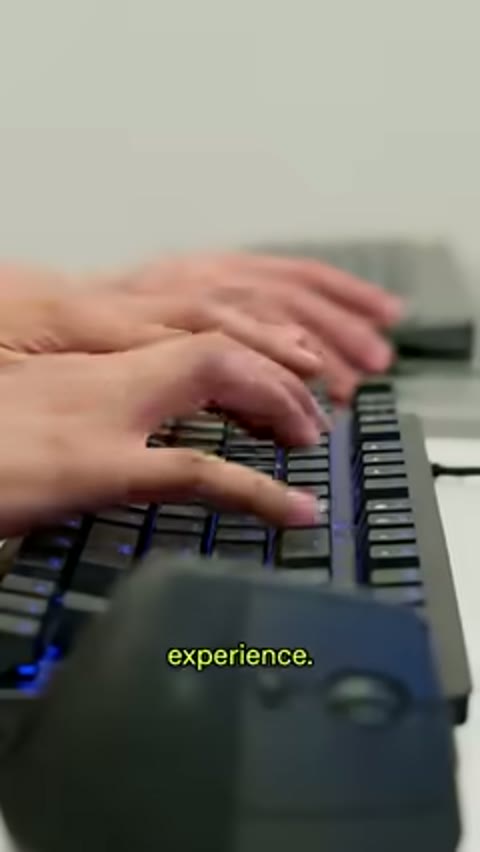 Source frame at 50.500s. Interviewee, keyboard hands, scratch-card hands and cartoon figure.