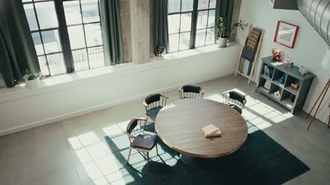 Source frame at 205.500s. Blue-shirted speaker, empty overhead table, logo.